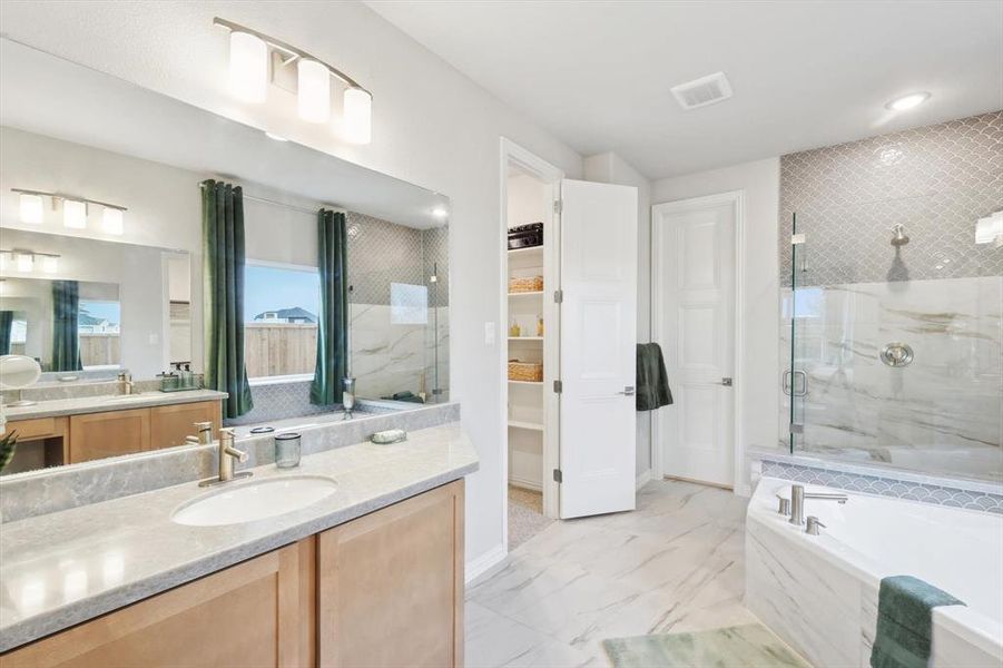 Bathroom with a garden tub, vanity, a marble finish shower, a spacious closet, and recessed lighting