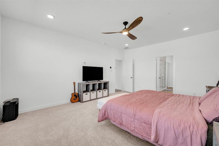 Carpeted bedroom featuring ceiling fan