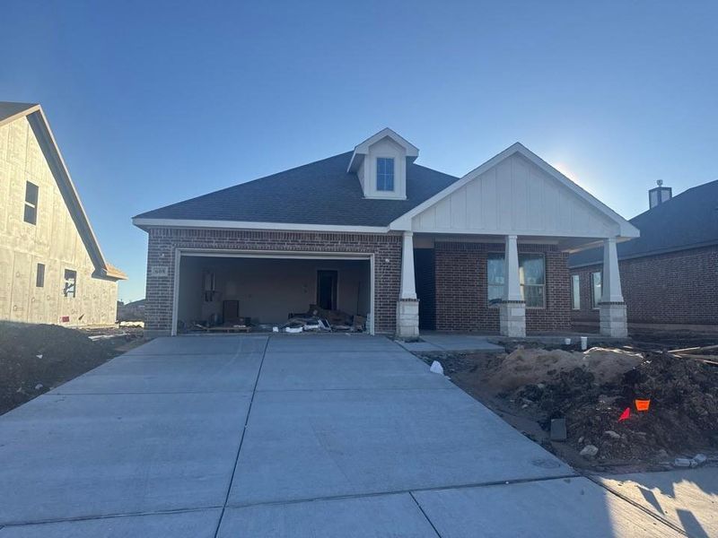Craftsman inspired home featuring brick siding, concrete driveway, board and batten siding, an attached garage, and covered porch Craftsman inspired home featuring brick siding, concrete driveway, board and batten siding, an attached garage, and covered porch
