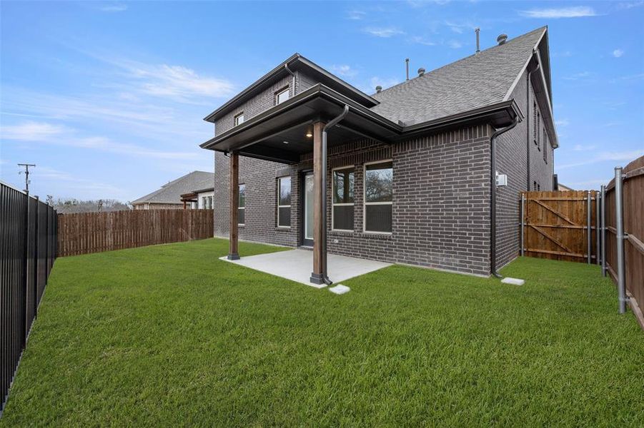 Back of house with brick siding, a patio, and a shingled roof