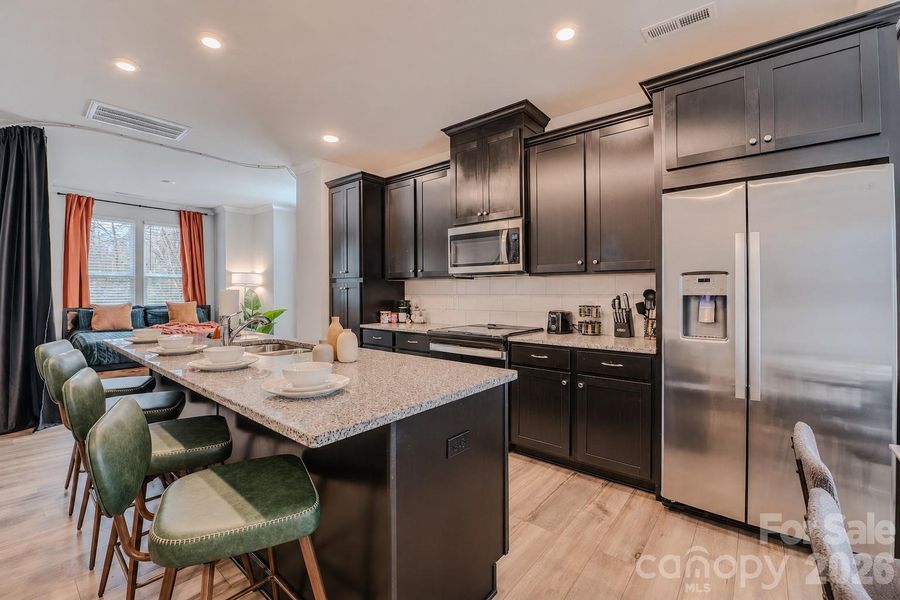 The modern kitchen showcases stainless steel appliances, abundant cabinetry, sleek quartz countertops, a subway tile backsplash, and ample prep space, creating the perfect blend of style and functionality. The modern kitchen showcases stainless steel appliances, abundant cabinetry, sleek quartz countertops, a subway tile backsplash, and ample prep space, creating the perfect blend of style and functionality.