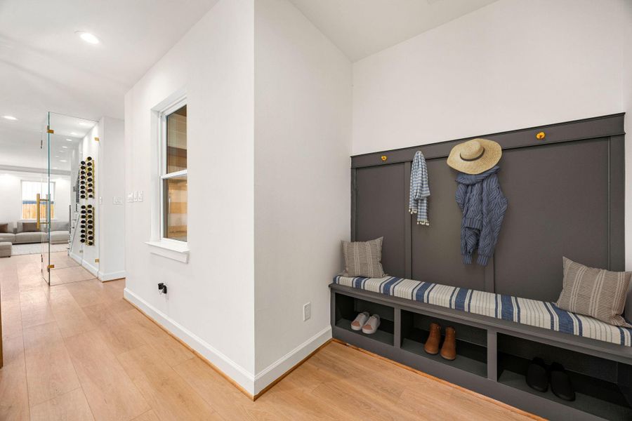 A welcoming entryway features custom built-in storage with seating, offering a functional and stylish space for everyday arrivals and departures while maintaining a clean, streamlined look.