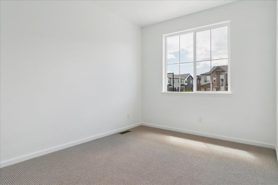 A room with a window and a carpet.