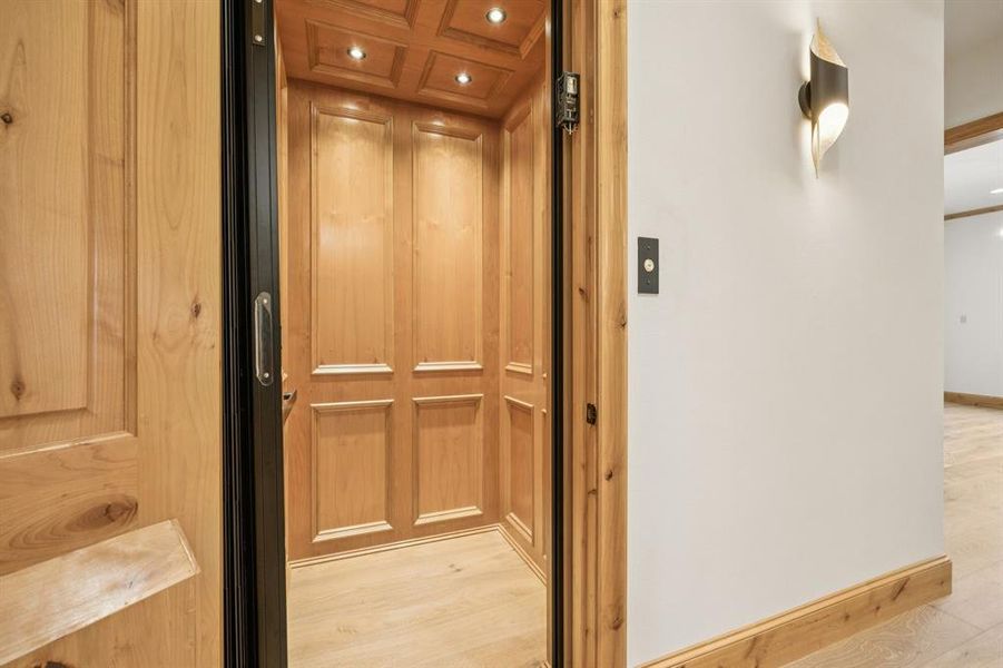 Elevator with recessed lighting and wood finished floors