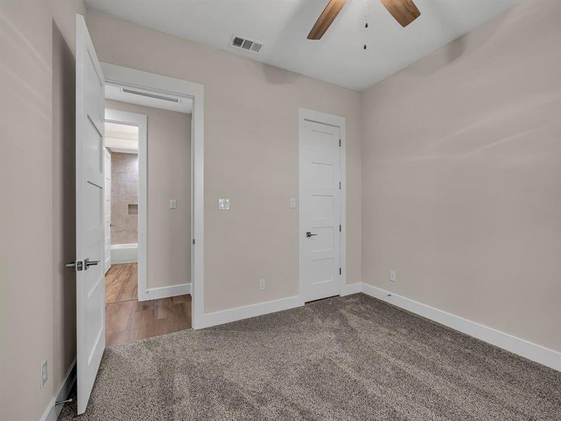 Unfurnished bedroom with ceiling fan and carpet floors