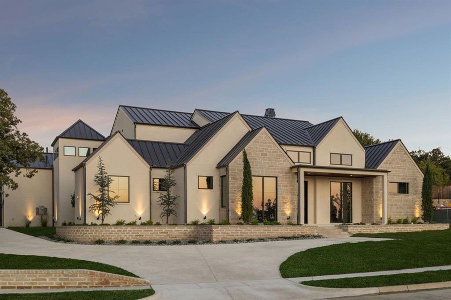 Modern farmhouse style home featuring a standing seam roof, a metal roof, stone siding, and stucco siding Modern farmhouse style home featuring a standing seam roof, a metal roof, stone siding, and stucco siding