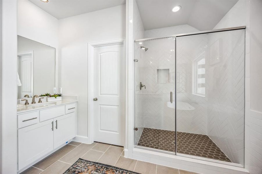 The separate walk-in shower—adorned with Moen fixtures and thoughtful touches like a shampoo nook—melds luxury with functionality.