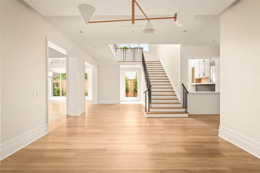 A natural extension of the dining space, this view reveals the home’s open-concept design, highlighted by a sculptural staircase and abundant natural light