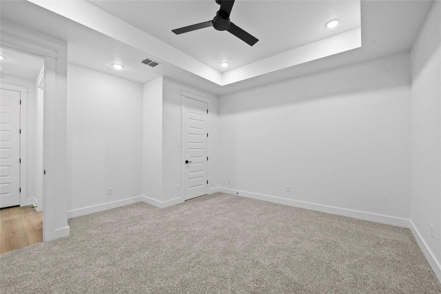 Spare room featuring a raised ceiling, light colored carpet, a ceiling fan, and recessed lighting Spare room featuring a raised ceiling, light colored carpet, a ceiling fan, and recessed lighting