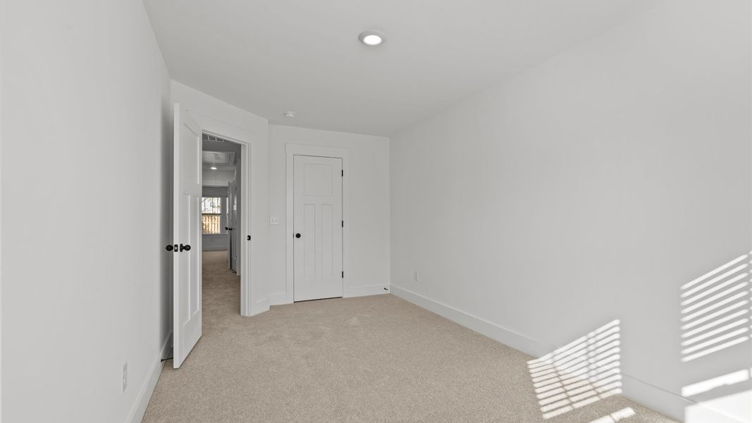 Elegant bedroom retreat featuring soft carpeting and a thoughtfully designed walk-in closet