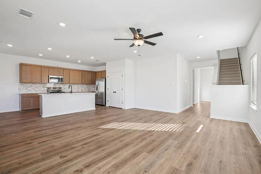 An open-concept living space integrates a well-appointed kitchen with warm wooden cabinetry and durable flooring. An open-concept living space integrates a well-appointed kitchen with warm wooden cabinetry and durable flooring.