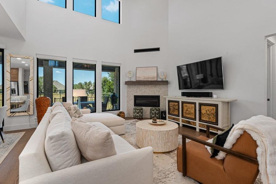 A great room offers soaring ceilings, a modern fireplace, and expansive windows that frame outdoor living space. A great room offers soaring ceilings, a modern fireplace, and expansive windows that frame outdoor living space.