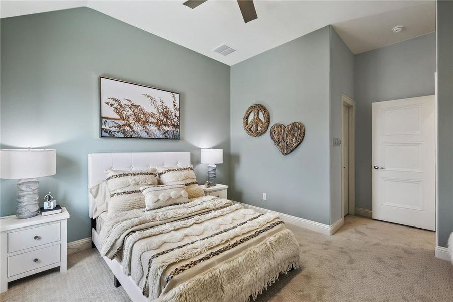 Vaulted ceiling with a ceiling fan, light gray wall paint, white trim, and light-colored carpet flooring