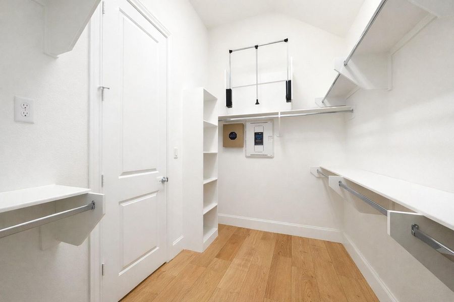 Huge primary closet (1 of 2) with shelving all around and pulldowns create even more space.