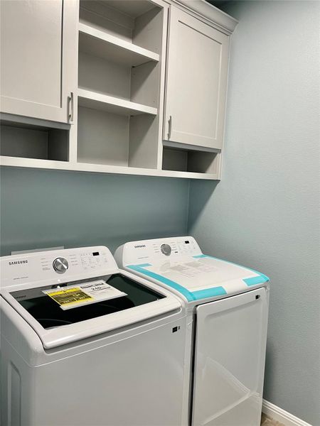 This picture is of the appliances when they were brand new.  These are the same ones that will convey but they are 2 years old now.  Smartly designed laundry area features functional cabinetry and efficient appliances.