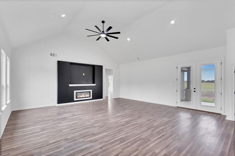 Spacious living area featuring a vaulted ceiling, recessed lighting, and a contemporary fireplace with a media niche