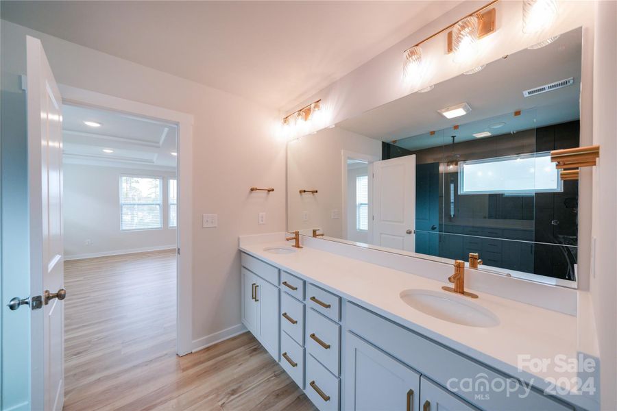 Primary Bathroom features upgraded cabinets, quartz countertops, upgraded lighting and faucet packages