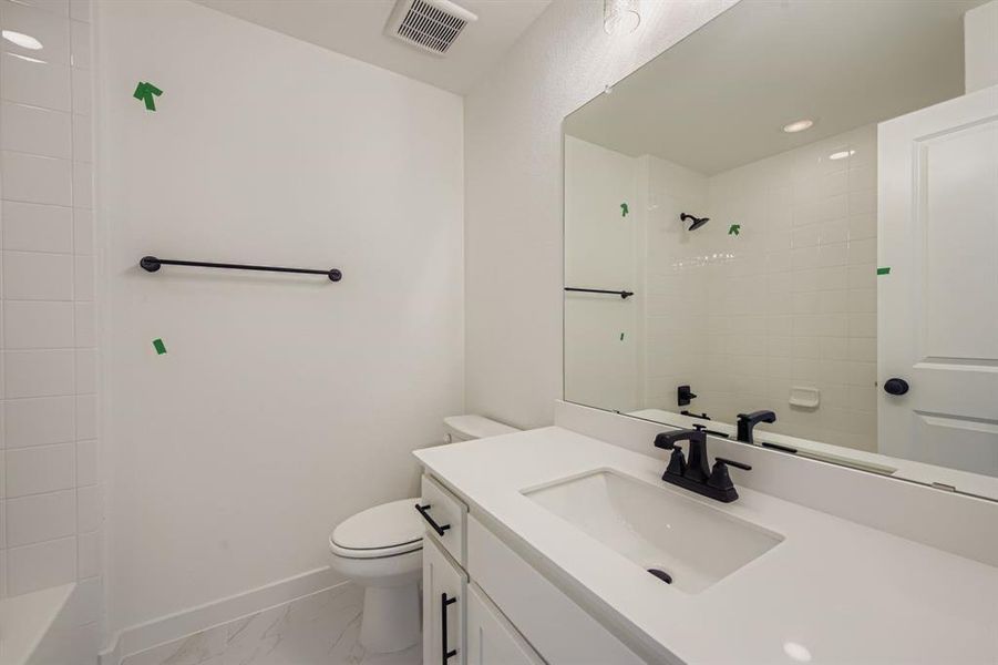 Full bath featuring vanity, recessed lighting, light marble finish flooring, and shower / bath combination