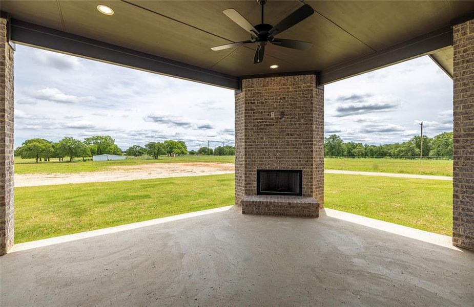 View of patio with an outdoor brick fireplace and a ceiling fan View of patio with an outdoor brick fireplace and a ceiling fan