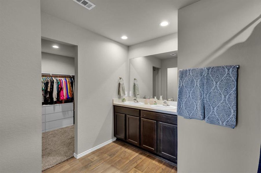 Primary bathroom features double sinks and a spacious vanity with a large mirror, providing a stylish and functional area for daily routines. The layout enhances convenience and comfort, making this bathroom a perfect retreat.