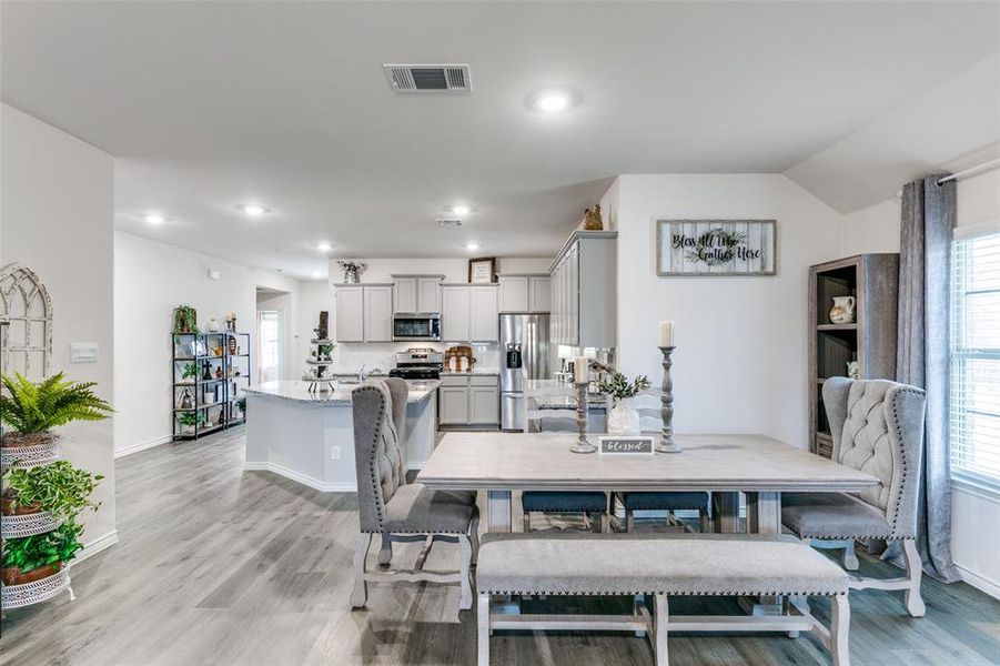 Dining room featuring lofted ceiling and light wood-type flooring