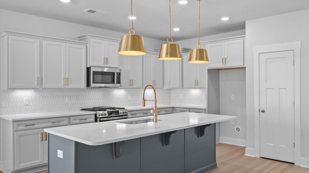 Elegant kitchen featuring a 8-foot island with pendant lighting and tasteful finishes throughout
