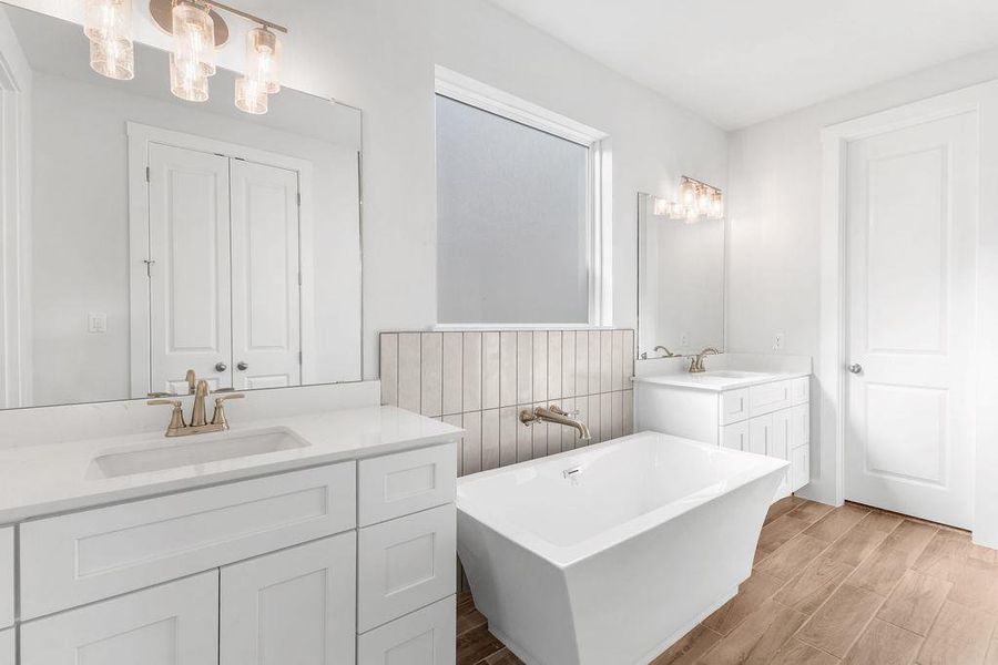 Luxurious primary bath with dual vanities and a freestanding soaking tub. Luxurious primary bath with dual vanities and a freestanding soaking tub.
