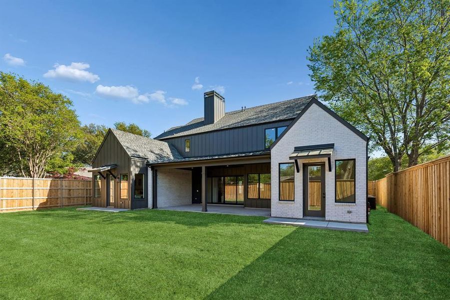 Rear view of property with a patio, a fenced backyard, brick siding, and a chimney