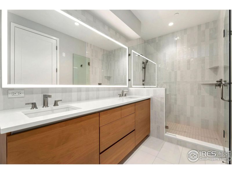 Gorgeous primary bathroom with walk-in shower, free standing tub and lit mirror