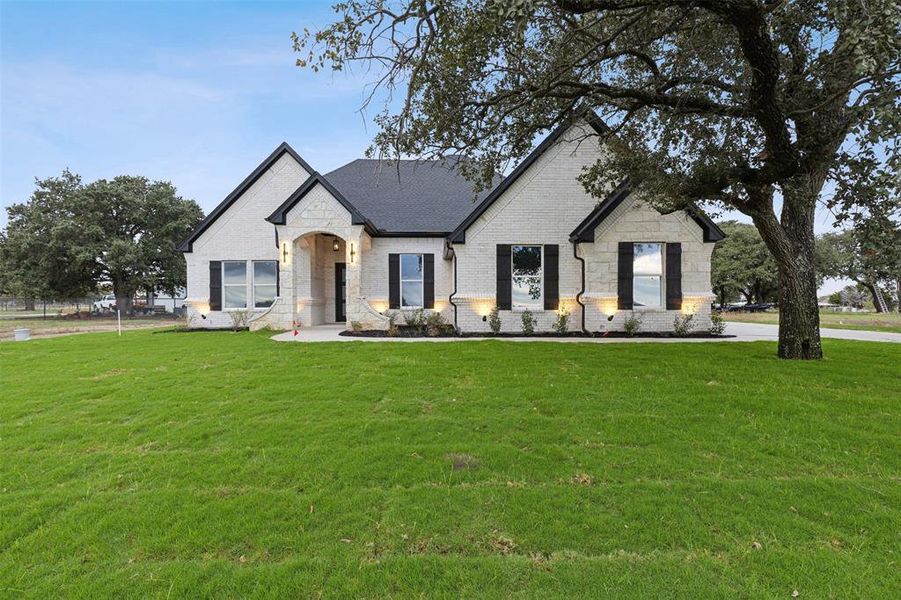 French provincial home with a front lawn