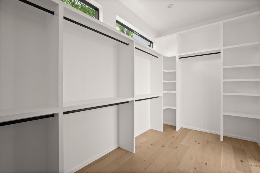 Walk in closet with light wood-style floors