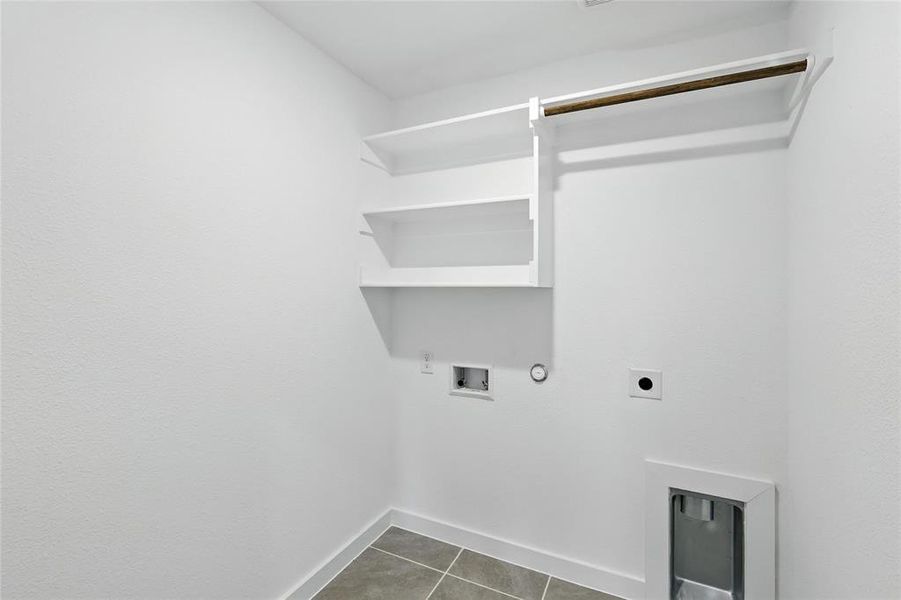 Laundry room featuring gas dryer hookup, hookup for an electric dryer, hookup for a washing machine, and dark tile patterned flooring Laundry room featuring gas dryer hookup, hookup for an electric dryer, hookup for a washing machine, and dark tile patterned flooring