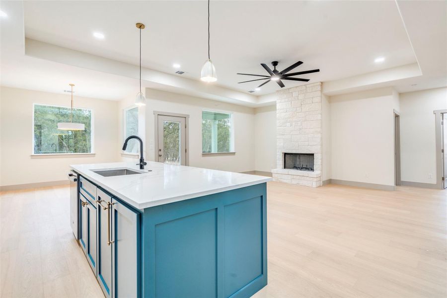 Kitchen with blue cabinetry, a raised ceiling, pendant lighting, and recessed lighting
