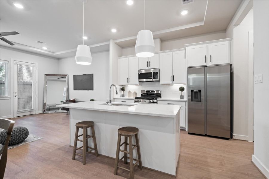 A central island with seating anchors the kitchen and supports both quick mornings and casual hosting.