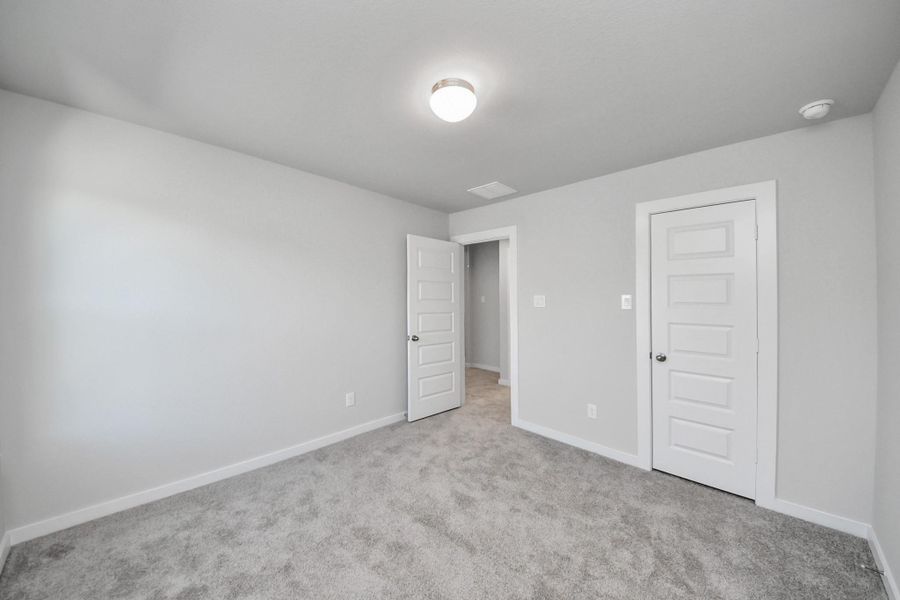 Generously sized secondary bedrooms featuring spacious closets, soft and inviting carpeting underfoot, large windows allowing plenty of natural light, and the added touch of privacy blinds for your personal retreat. Sample photo of completed home with similar floor plan. Actual colors and selections may vary.