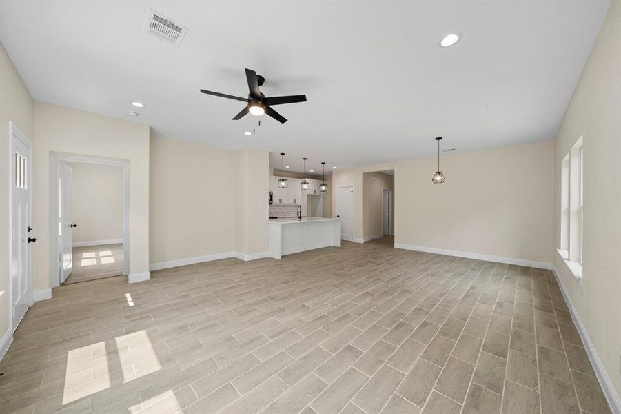 Unfurnished living room featuring sink and ceiling fan