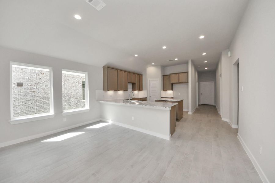 Make memories gathered around the table with your family and friends! This spacious dining room features elegant flooring, custom paint, and adjacent to family room and kitchen for open concept feel. Sample photo of completed home with similar floor plan. Actual colors and selections may vary.