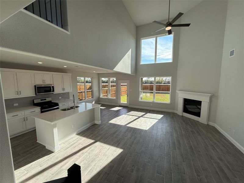 Kitchen with range with electric stovetop, white cabinets, a wealth of natural light, and high vaulted ceiling