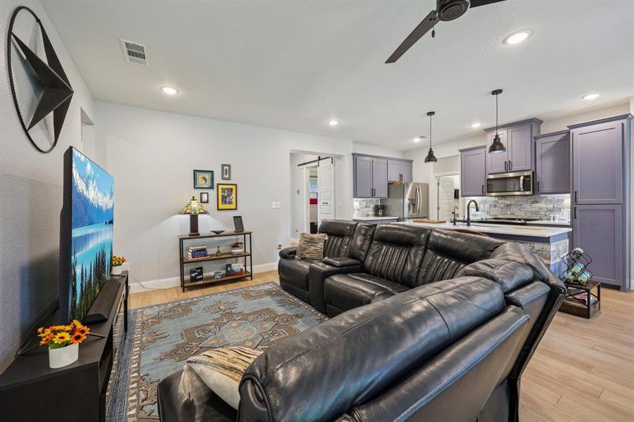 Living area with light wood finished floors, recessed lighting, and a ceiling fan Living area with light wood finished floors, recessed lighting, and a ceiling fan