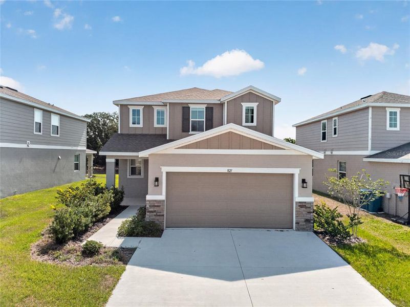 Front exterior of a new home in Seasons at Forest Creek, Haines City, FL, highlighting curb appeal (Image 29).