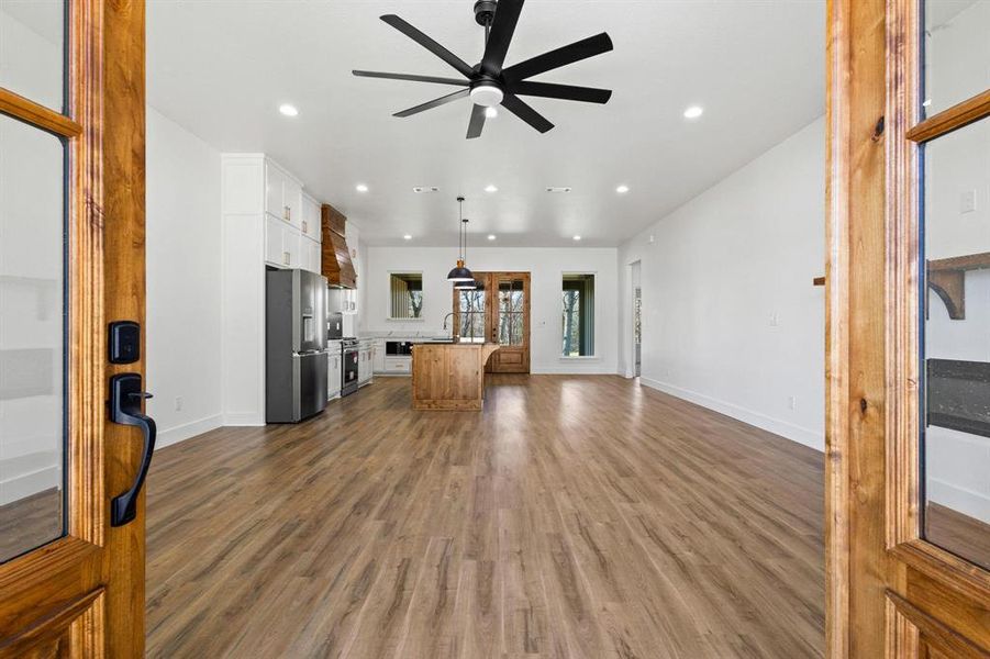 Living room with dark hardwood / wood-style flooring and ceiling fan