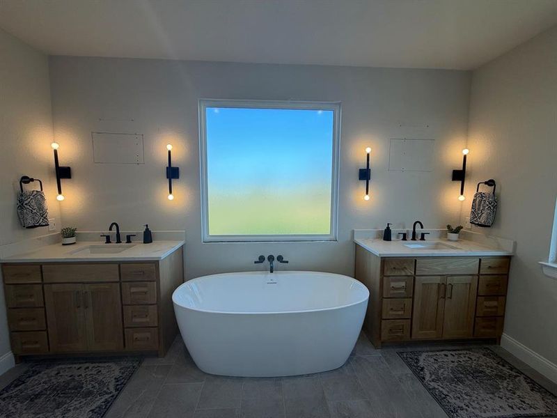 Bathroom with two vanities and a freestanding tub