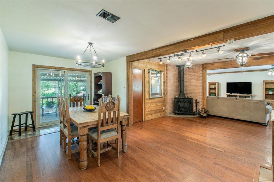 Dining area with rustic charm and a freestanding wood-burning stove that serves as a warm focal point. Dining area with rustic charm and a freestanding wood-burning stove that serves as a warm focal point.