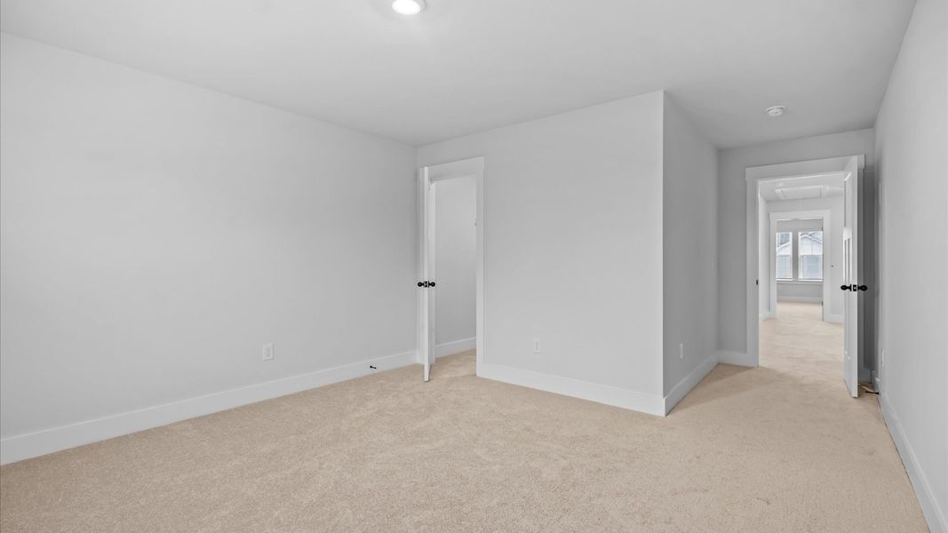 Vibrant & inviting secondary bedroom featuring a walk-in closet at Silo Ridge by DRB Homes in Anderson, SC