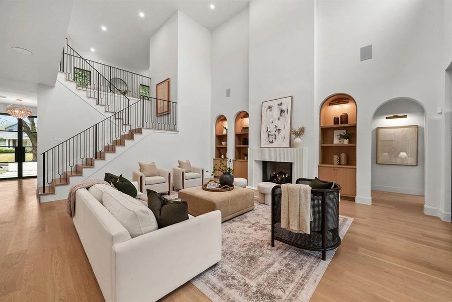 Living area with built in features, a high ceiling, french doors, a fireplace, and arched walkways Living area with built in features, a high ceiling, french doors, a fireplace, and arched walkways
