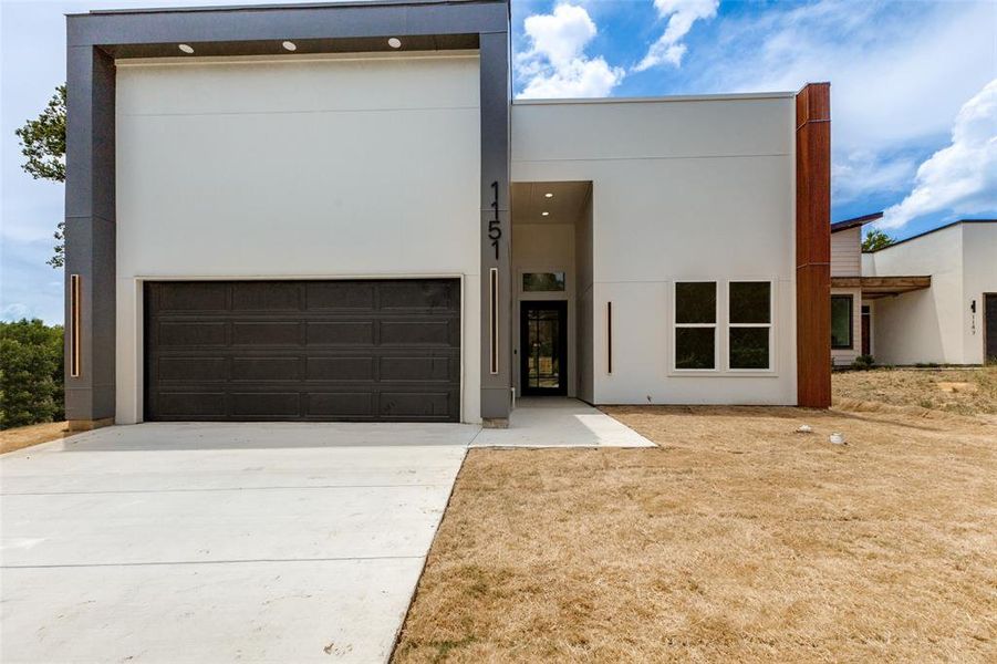 Contemporary white stucco exterior with a dark gray garage door Contemporary white stucco exterior with a dark gray garage door