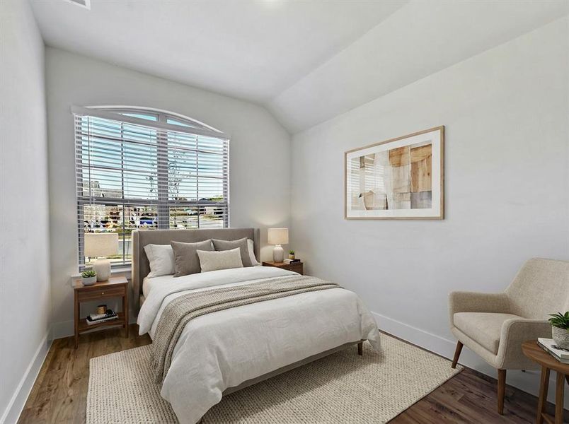 Room featuring an arched window & wood-finish flooring that could be used as a bedroom or an office as shown in the photo