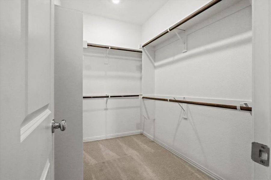 Walk in closet featuring light colored carpet Walk in closet featuring light colored carpet