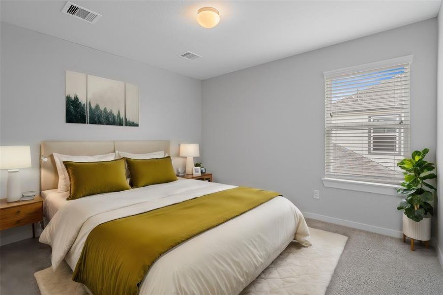 Secondary bedroom features plush carpet, custom paint and a large window with privacy blinds.