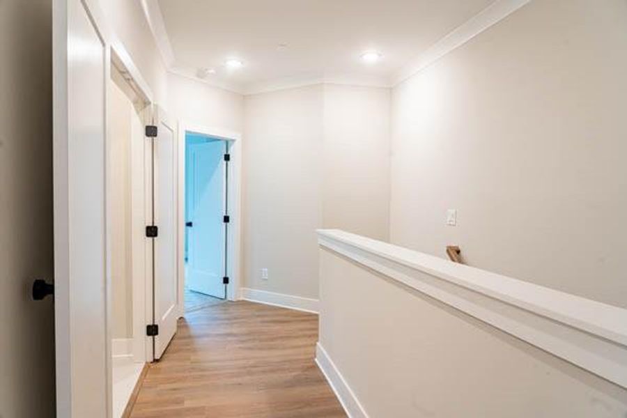 Hall with ornamental molding and light wood-type flooring Hall with ornamental molding and light wood-type flooring